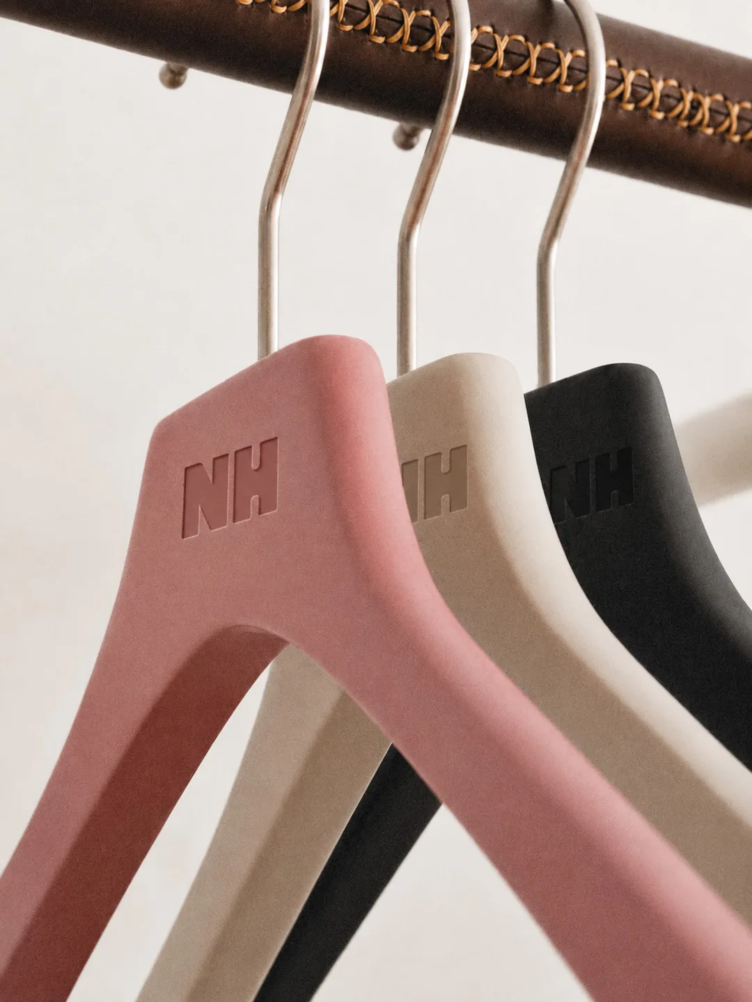 Three NH hangers — pink, cream and chocolate