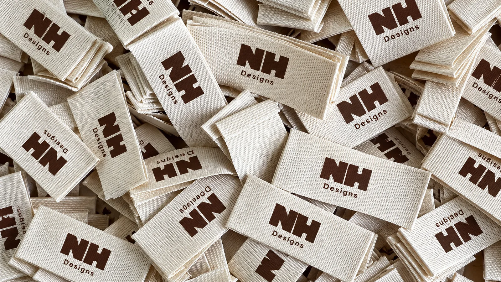 A pile of woven NH Designs labels